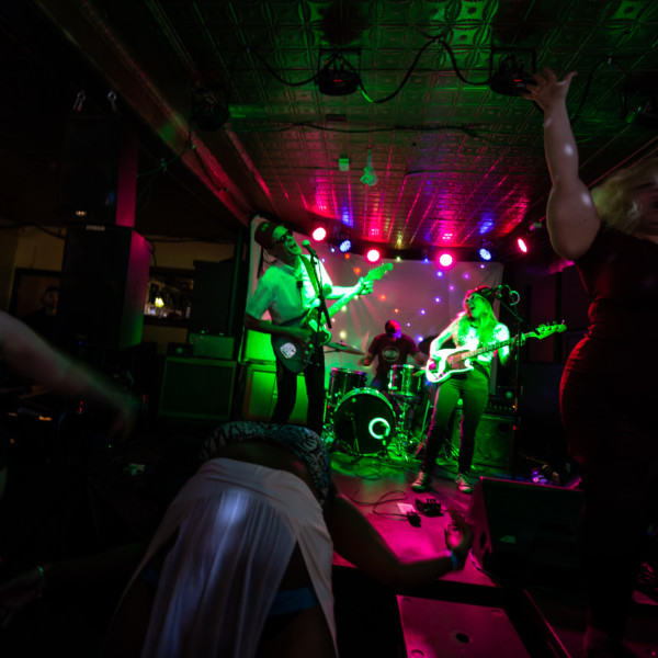 The Wet Ones performing on stage in front of a dancing crowd