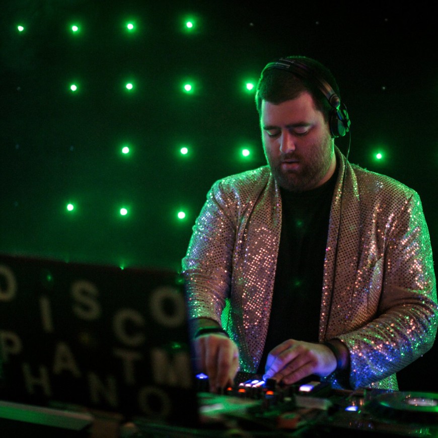 DJ Disco Phantom wears a sparkly blazer while he DJs