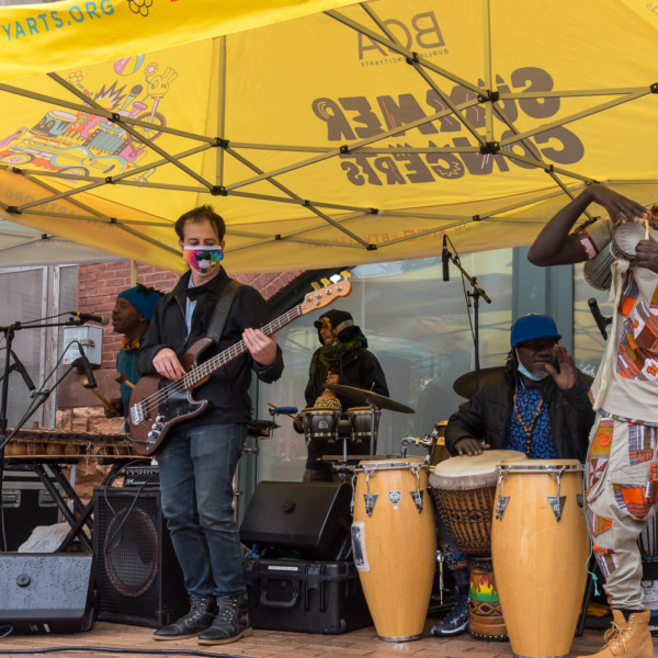 Sabouyouma performs during the Summer Concert Series under a yellow tent