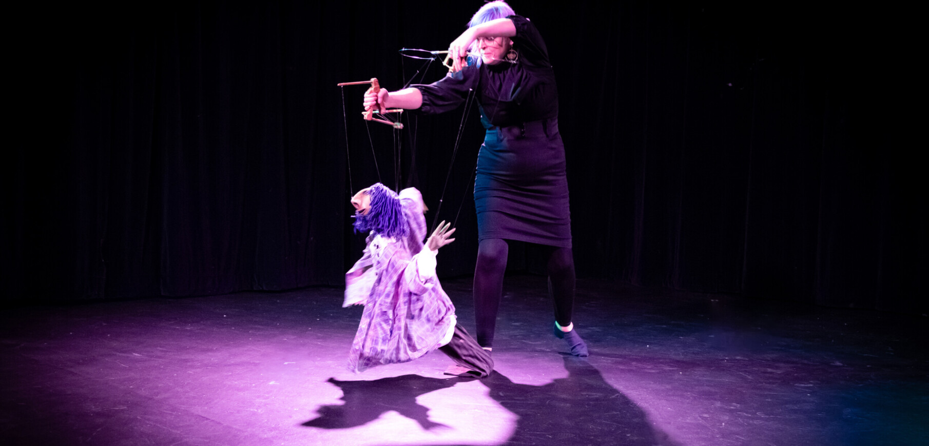 a person holds a puppet on a stage