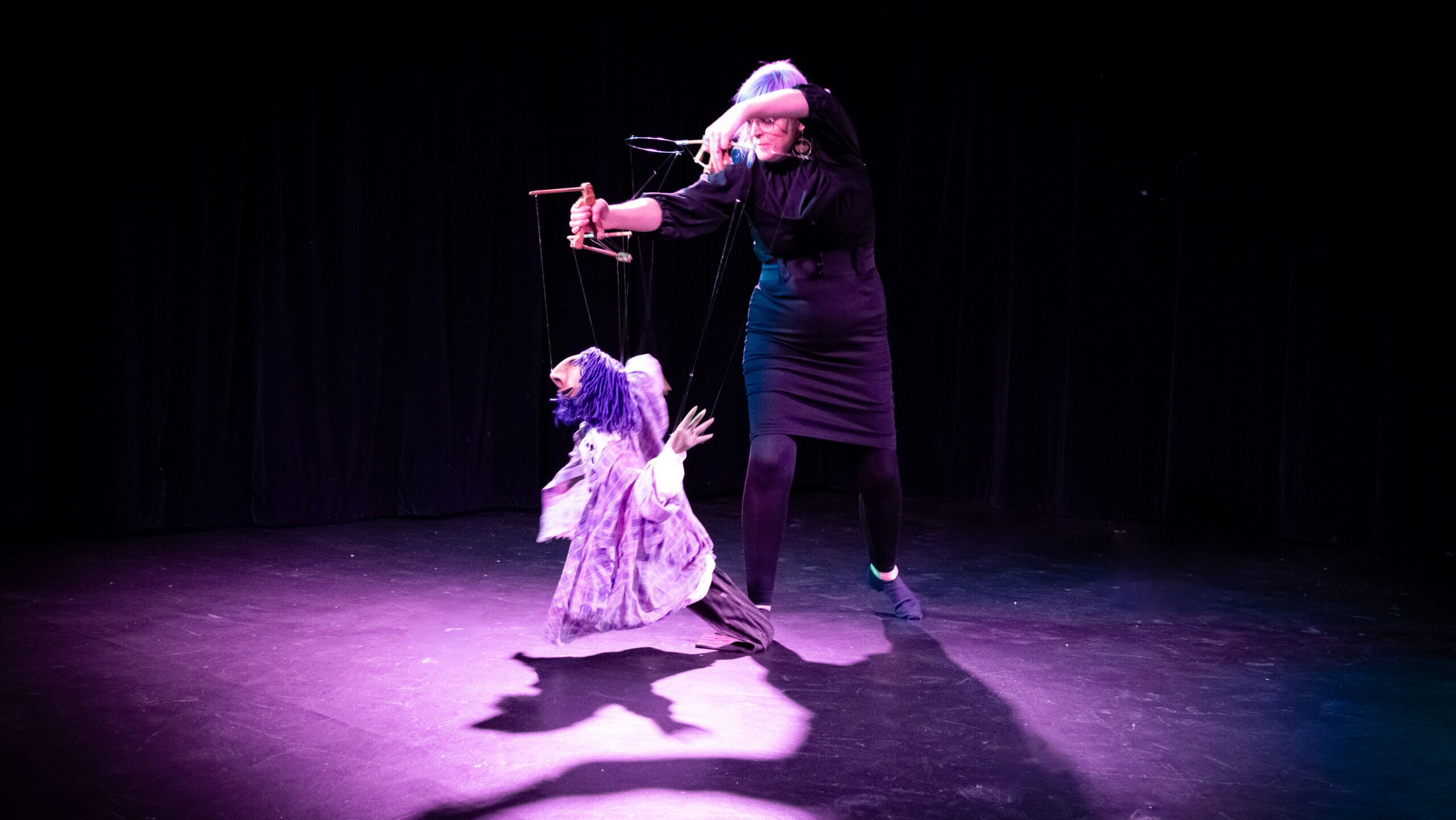 a person holds a puppet on a stage
