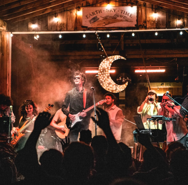 A band performs in a barn to an excited crowd.