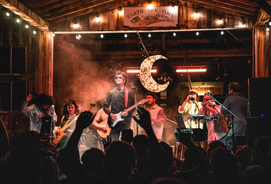 A band performs in a barn to an excited crowd.