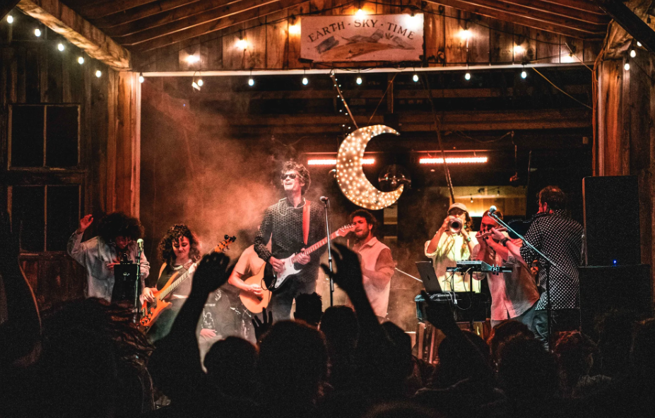 A band performs in a barn to an excited crowd.